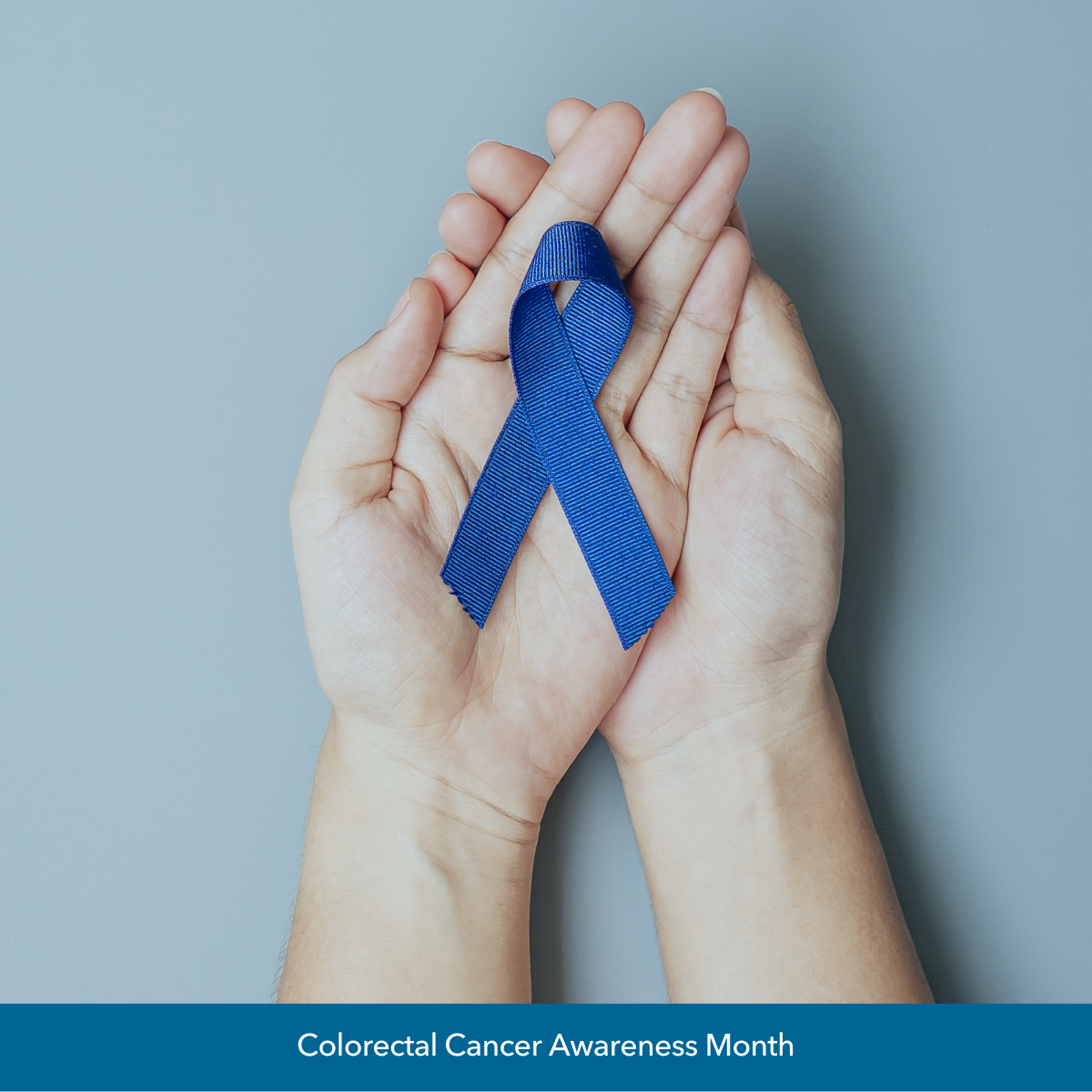 Image of pair of hands holding blue cancer ribbon