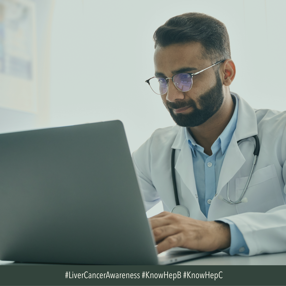 Image of young male doctor in front of a laptop